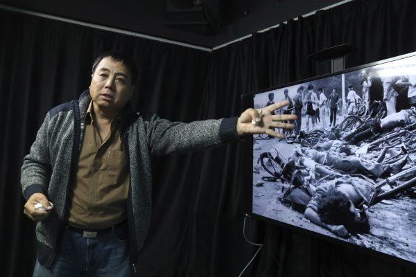 Dong Shengkun gestures as he recalls being present at the scene seen in the photo when tanks ran down students taking part in the 1989 pro democracy protests during an interview in Beijing on April 28, 2019. (Ng Han Guan/AP)