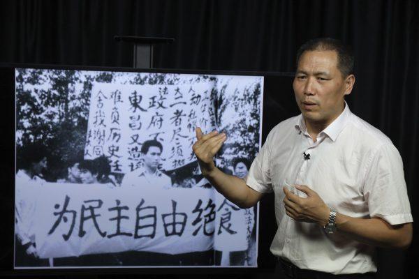 Pu Zhiqiang recalls his experience near a photo which showed him taking part in the 1989 pro-democracy protest near a banner which reads "Hunger strike for democracy" during an interview in Beijing on May 22, 2019. Then a graduate student, Pu remained in China despite his role in the protests as a high-profile advocate of speech and press freedoms. (Ng Han Guan/AP)