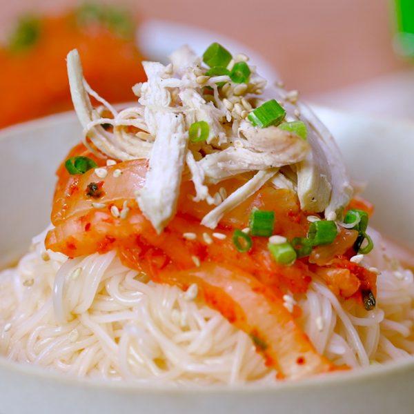 Rice noodle soup with kimchi and shredded chicken.