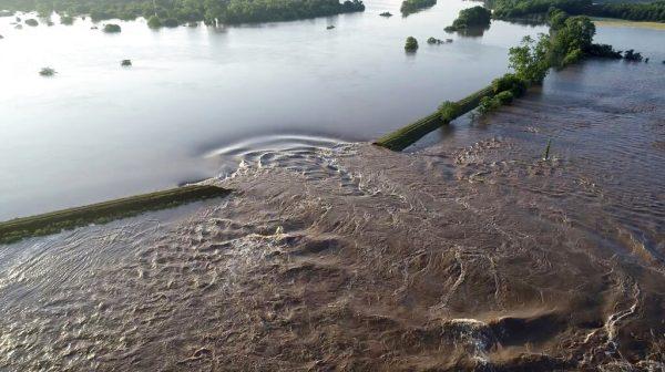 In this aerial image provided by Yell County Sheriff's Department water rushes through the levee along the Arkansas River, Dardanelle, Ark., on May 31, 2019. (Yell County Sheriff's Department via AP)