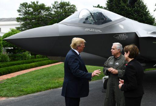 President Donald Trump speaks with Alan B. Norman (C), director and chief test pilot, and Marillyn A. Hewson, chairman, president, and chief executive officer of Lockheed Martin, next to an F-35 during the "Made in America" showcase event at the White House gardens in Washington on July 23, 2018. Brendan Smialowski / AFP