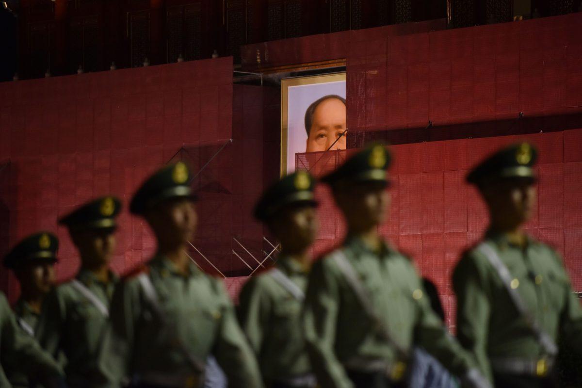 Paramilitary police officers marching past the portrait of late communist leader Mao Zedong on Tiananmen Gate, as it undergoes renovations in Beijing, on May 18, 2019. (Greg Baker/AFP/Getty Images)