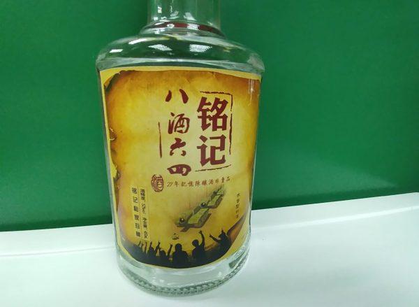 This photo taken on April 3, 2019 in Chengdu, China, shows a bottle of liquor with a label commemorating the 1989 Tiananmen crackdown with an illustration of "Tank Man"–a renowned photograph of a single individual facing down a column of armored vehicles—and script that reads "Always remember June 4th, 1989." Four activists in southwestern China have been handed prison sentences over liquor labels commemorating the 1989 Tiananmen massacre—two months before the crackdown's 30th anniversary, said rights groups and relatives. (STR/AFP/Getty Images)