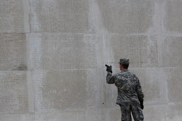 A soldier reads names on a wall of remembrance at the Cambridge American Cemetery in Madingley, UK, on Nov. 11, 2011. (Dan Kitwood/Getty Images)