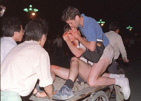 An unidentified foreign journalist (2nd-r) is carried out from the clash site between the army and students near Tiananmen Square in Beijing on June 4, 1989. According to Amnesty International, five years after the crushing of the Chinese pro-democracy movement, "thousands" of prisoners remained in jail. (Tommy Cheng/AFP/Getty Images)