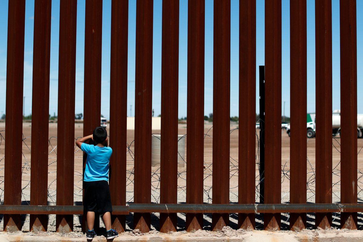 A child looks through the border wall during the visit of U.S. President Donald Trump to Calexico, California, as seen in Mexicali, Mexico, on April 5, 2019. (Reuters/Carlos Jasso)