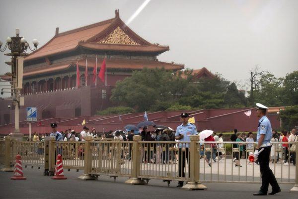 Security officials stand guard in front of Tiananmen Gate next to Tiananmen Square in Beijing on June 4, 2019. (Mark Schiefelbein/AP)