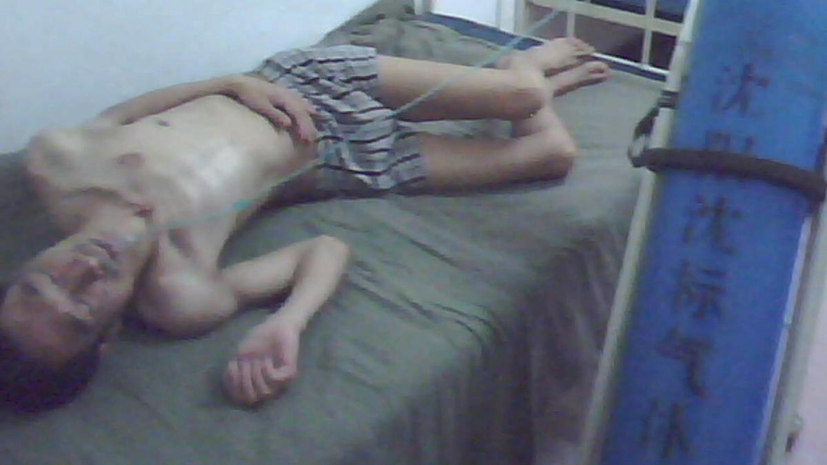Undercover Footage from Masanjia Forced Labor Camp showing a Falun Gong practitioner lying on bed after being tortured for protesting against the persecution. Shot during the 2008 Beijing Olympics. (Courtesy of Yu Ming)
