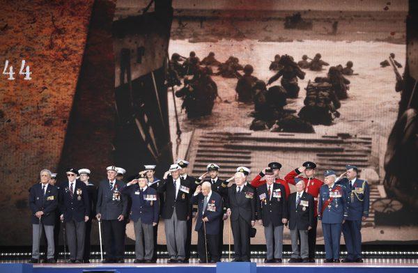 D-Day veterans, front row, stand on stage during an event to mark the 75th anniversary of D-Day in Portsmouth, England, June 5, 2019. (AP Photo/Matt Dunham)