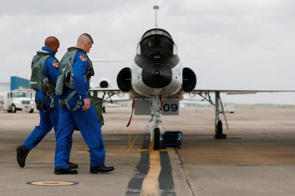 NASA commercial crew astronauts Victor Glover and Michael Hopkins walk out to their aircraft prior to a training flight in Houston, Texas on May 21, 2019. (Mike Blake/Reuters)