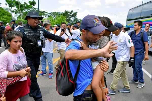 A federal police officer escorts detained migrants during a joint operation by the Mexican government to stop a caravan of Central American migrants on their way to the U.S., at Metapa de Dominguez, in Chiapas state, Mexico, on June 5, 2019. (Jose Torres/Reuters)
