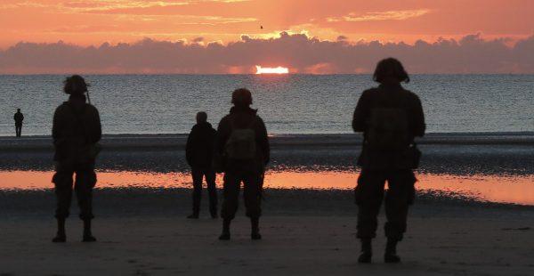 World War II reenactors gather at dawn on Omaha Beach, in Normandy, France on June 6, 2019, during commemorations of the 75th anniversary of D-Day. (Thibault Camus/Photo/AP)