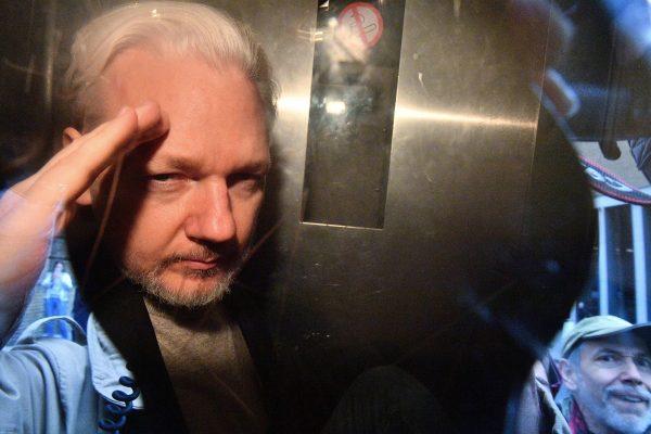WikiLeaks founder Julian Assange gestures from the window of a prison van as he is driven out of Southwark Crown Court in London on May 1, 2019. (Daniel Leol-Olivas/AFP/Getty Images)