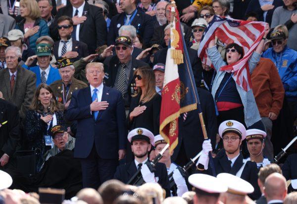 U.S. President Donald Trump (C-L) joins in in singing the American national anthem as First Lady Melania Trump looks on at the main ceremony to mark the 75th anniversary of the World War II Allied D-Day invasion of Normandy as American Battle of Normandy veterans and family members look on at Normandy American Cemetery on June 06, 2019 near Colleville-Sur-Mer, France. Veterans, families, visitors, political leaders and military personnel are gathering in Normandy to commemorate D-Day, which heralded the Allied advance towards Germany and victory about 11 months later. (Sean Gallup/Getty Images)