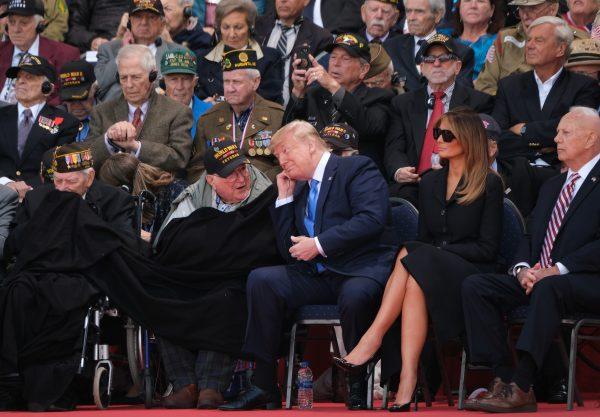 U.S. President Donald Trump (C) chats with an American veteran of The Battle of Normandy as First Lady Melania Trump looks on at the main ceremony to mark the 75th anniversary of the World War II Allied D-Day invasion of Normandy as American Battle of Normandy veterans and family members look on at Normandy American Cemetery on June 06, 2019 near Colleville-Sur-Mer, France. Veterans, families, visitors, political leaders and military personnel are gathering in Normandy to commemorate D-Day, which heralded the Allied advance towards Germany and victory about 11 months later. (Sean Gallup/Getty Images)