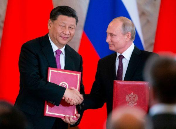 Chinese leader Xi Jinping and Russian President Vladimir Putin exchange documents during a signing ceremony following their talks at the Kremlin in Moscow on June 5, 2019. (Alexander Zemlianichenko/AFP via Getty Images)