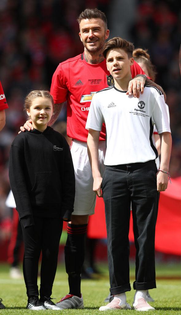 David Beckham with his children Harper and Cruz at Old Trafford in Manchester, England, in 2019 (©Getty Images | <a href="https://www.gettyimages.com/detail/news-photo/david-beckham-of-manchester-united-99-legends-pictured-with-news-photo/1151823186?adppopup=true">Matthew Lewis</a>)