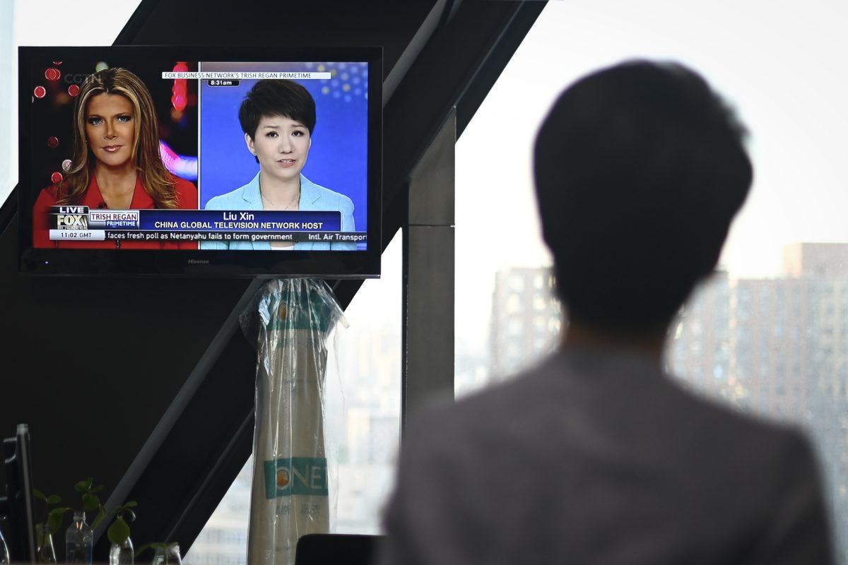 China's state broadcaster CGTN anchor Liu Xin looks at a screen showing her debate with Fox Business Network presenter Trish Regan, at the CCTV headquarters in Beijing on May 30, 2019. (Wang Zhao/AFP/Getty Images)