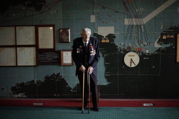 British D-Day veteran Leonard 'Ted' Emmings poses for photographs backdropped by the map used to plan the Normandy D-Day landings during a D-Day 75th anniversary media facility at Southwick House near Portsmouth, England. On May 9, 2019. (AP Photo/Matt Dunham)