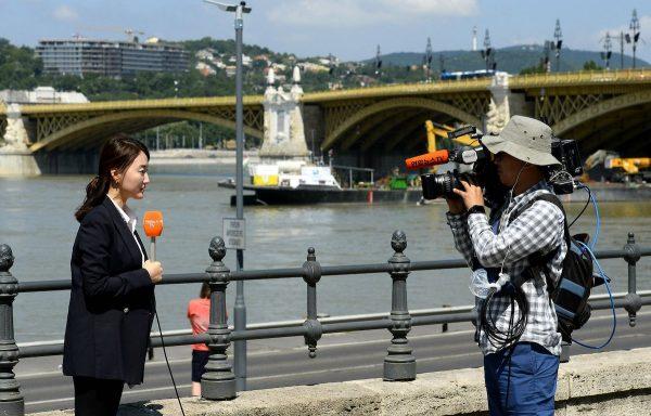 A Korean television crew works at Margaret Bridge, the scene of the deadly boat accident in Budapest, Hungary, on June 8, 2019. (Lajos Soos/MTI via AP)