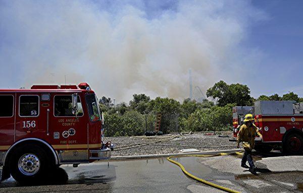 Los Angeles County firemen fight a brush fire burning close to Six Flags Magic Mountain and Hurricane Harbor amusement park in Santa Clarita, Calif., on June 9, 2019. (Rick McClure/AP)