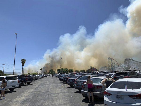 Heavy smoke from a fast-moving brush fire surrounds Six Flags Magic Mountain and Hurricane Harbor, in Santa Clarita, Calif., on June 9, 2019. (Joel Cannon via AP)