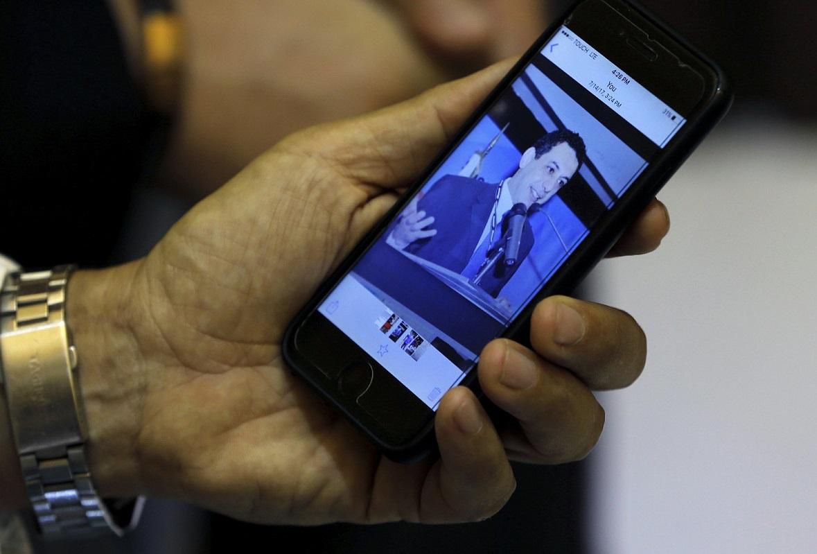Ziad Zakka, brother of Nizar Zakka who is imprisoned in Iran, shows a photo of his brother on his cellular telephone in Beirut, Lebanon, on July 18, 2017. (Bilal Hussein/AP Photo)