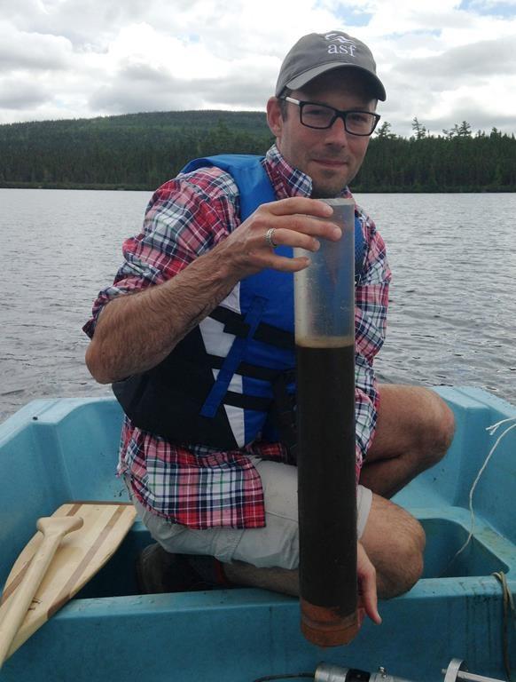 Environmental scientist and lead author Dr. Josh Kurek with a lake sediment core from Sinclair Lake, New Brunswick is shown in this handout image. (HO-Dr.Josh Kurek/The Canadian Press)
