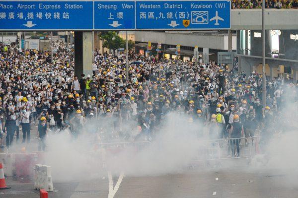 Protestors are shrouded in tear gas during a protest against a proposed extradition bill, near Hong Kong's Legislative Council on June 12, 2019. (Song Bilong/The Epoch Times)