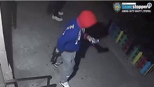 The suspect is seen holding a cell phone and with a rifle at his side. (NYPD)