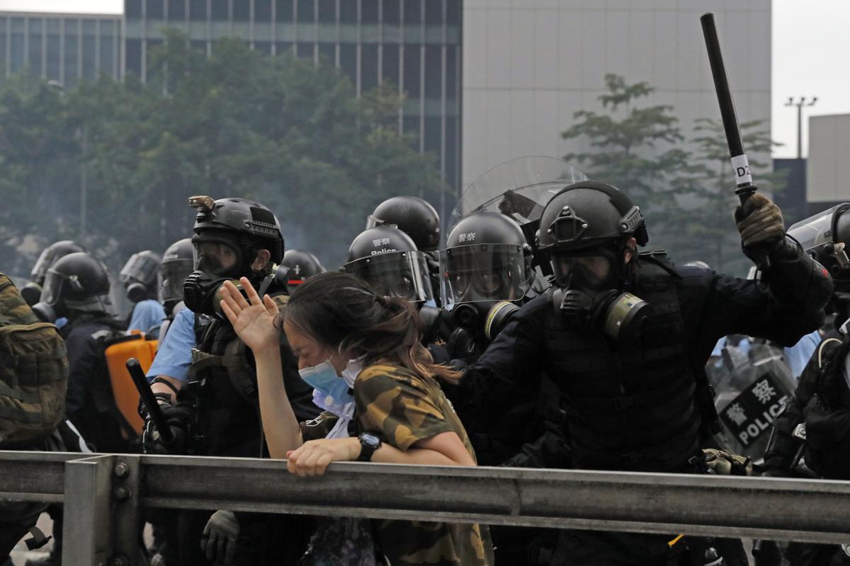 A protester reacts as she is tackled by a riot police officer near the Legislative Council in Hong Kong. (Kin Cheung/AP)