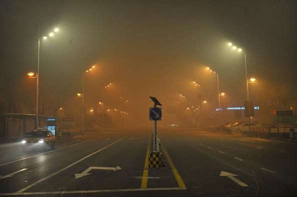 A car driving at night through thick smog in Harbin City. (VCG via Getty Images)