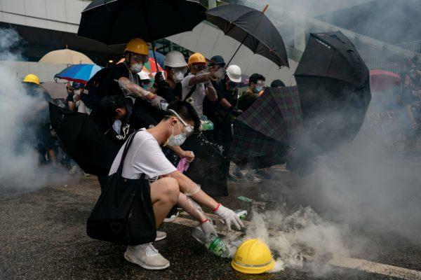 Protesters pour water on to a teargas canister during a protest in Hong Kong on June 12, 2019. (Anthony Kwan/Getty Images)