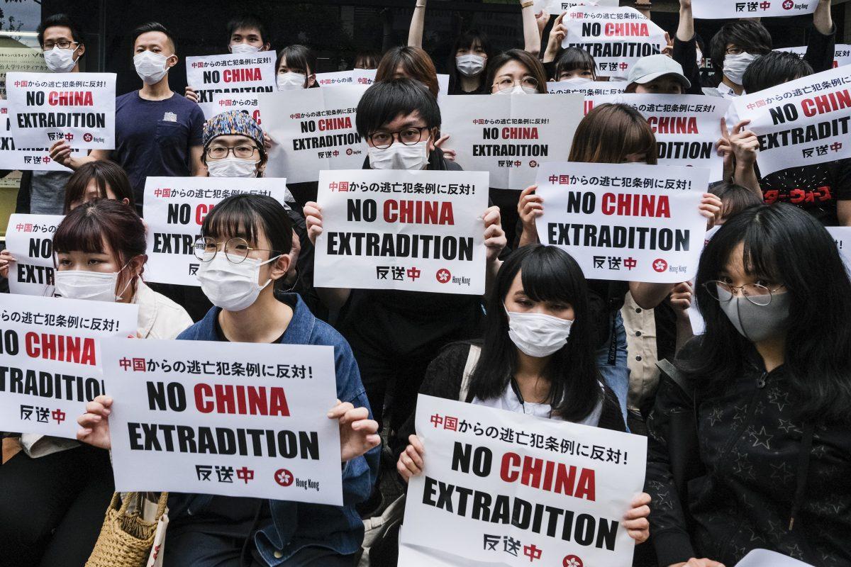Foreign students In Japan hold up a placard which says No China Extradition at Meiji University in Tokyo, Japan on June 12, 2019. (Keith Tsuji/Getty Images)