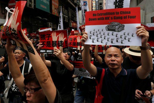 Protesters hold placards as they attend a demonstration demanding Hong Kong's leaders to step down and withdraw the extradition bill, in Hong Kong on June 16, 2019. (Reuters/Tyrone Siu)