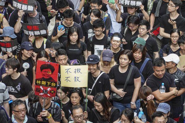 Hongkongers took the streets on June 16, 2019<strong> </strong>to demand the extradition bill’s full retraction and Hong Kong leader Carrie Lam’s resignation. The banners read “Students Are Not Rioters,” “Carrie Lam Step Down,” and “No Retreat without Retraction.” (Gang Yu/The Epoch Times)