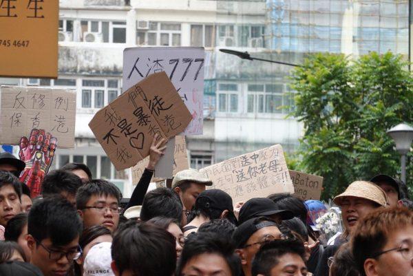 Hong Kong protesters hold up different signs in a march on June 16, 2019. One of the signs read “We are not rioters. We love Hong Kong.” (Yu Gang/The Epoch Times)