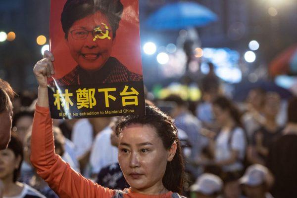A woman holds a poster of Hong Kong Chief Executive Carrie Lam, against a proposed extradition law, before a candlelight vigil for the 30th anniversary of the 1989 Tiananmen crackdown in Beijing at Victoria Park in Hong Kong on June 4, 2019. (PHILIP FONG/AFP/Getty Images)