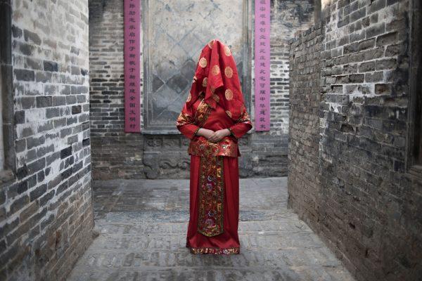 A Chinese woman dressed with a traditional bride costume. ( Fred Dufour/AFP/Getty Images)