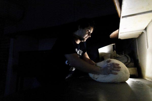 A pizza maker uses battery powered lamps to illuminate his work space during a blackout inside the delivery-only pizza shop in Buenos Aires, Argentina on June 16, 2019. (Tomas F. Cuesta/Photo via AP)