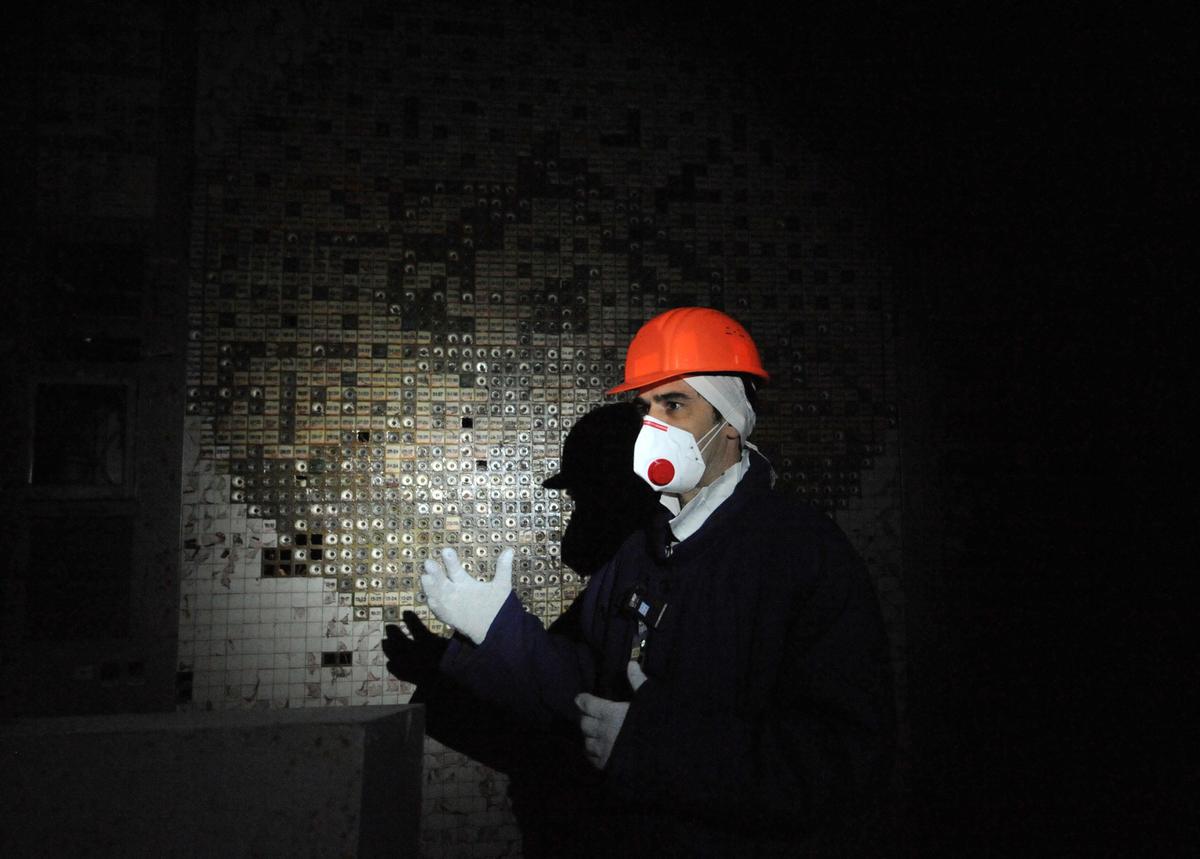 An employee of the Chernobyl Nuclear Power Plant walks in the control room of the destroyed 4th block of the plant. (©Getty Images | <a href="https://www.gettyimages.com/detail/news-photo/an-employee-of-the-chernobyl-nuclear-power-plant-walks-in-news-photo/110890553?adppopup=true">SERGEI SUPINSKY</a>)