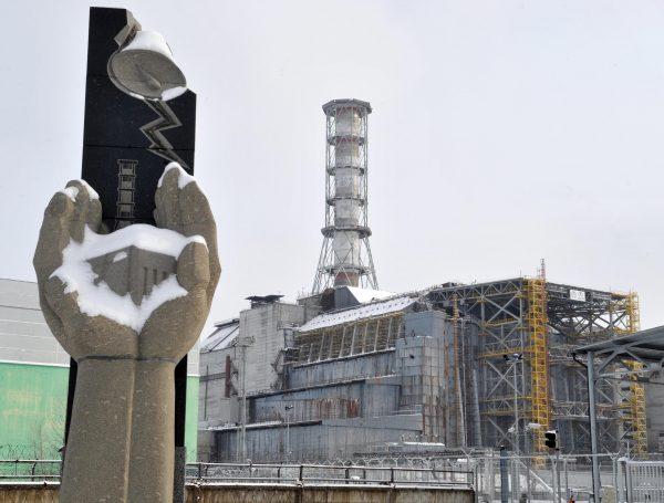 A memorial for the Chernobyl Nuclear Disaster victims is pictured in front of the sarcophagus covering the destroyed 4th power block of Chernobyl's nuclear power plant on Feb. 22, 2011, ahead of the 25th anniversary of the meltdown of reactor number four due to be marked on April 26, 2011. (Sergei Supinsky/AFP/Getty Images)
