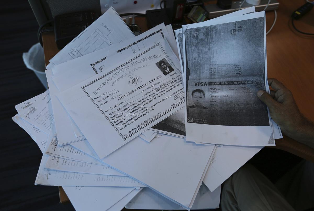A person shows photocopies of dozens of marriage contracts and other documents collected by a Pakistani security agency, in Islamabad, Pakistan on May 27, 2019. (B.K. Bangash/AP)