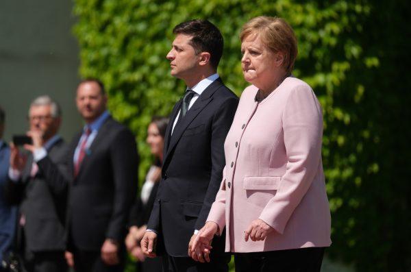 German Chancellor Angela Merkel listens to the German national anthem as she stands with Ukrainian President Volodymyr Zelensky at the Chancellery in Berlin, Germany, on June 18, 2019. (Sean Gallup/Getty Images)