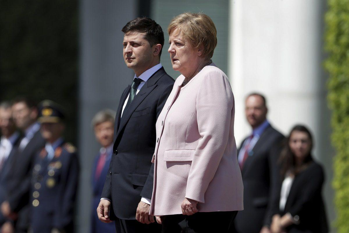 German Chancellor Angela Merkel (R) trembles strong as she and Ukraine's President Volodymyr Zelenskiy attend the national anthems as part of a military welcome ceremony in Berlin, Germany, on June 18, 2019. (Michael /AP Photo)