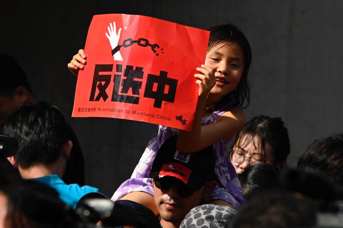 A young girl on her father's shoulders holds up a placard during a demonstration in Taipei in support of the continuing protests taking place in Hong Kong against a controversial extradition law proposal, on June 16, 2019. (Sam Yeh/AFP/Getty Images)