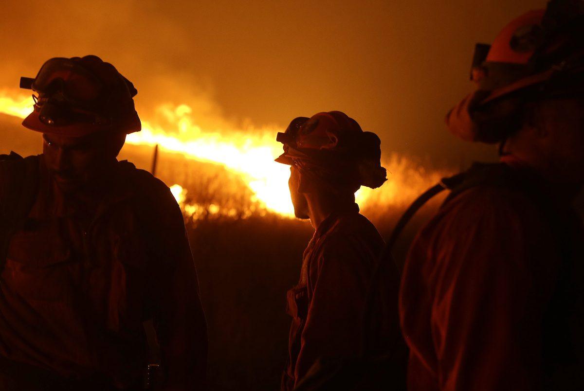 California Department of Corrections and Rehabilitation inmates stand guard as flames from the Butte Fire approach a containment line near San Andreas, Calif., on Sept. 12, 2015. (Rich Pedroncelli/AP Photo)