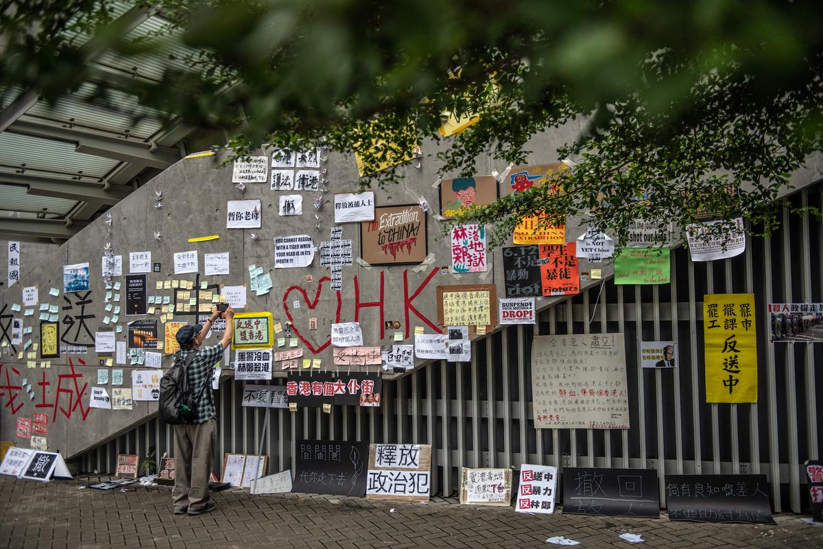 A man photographs protest posters on the wall of a stairway near the Legislative Council building on June 18, 2019 in Hong Kong. (Carl Court/Getty Images)