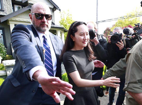 Huawei Technologies Chief Financial Officer Meng Wanzhou is escorted by security as she leaves her home on May 8, 2019 in Vancouver, Canada. (Jeff Vinnick/Getty Images)