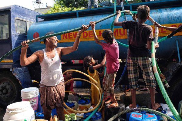 Indian residents stand around with plastic pots filled with drinking water at a distribution point in Chennai on June 19, 2019. (Arun Sankar/AFP/Getty Images)